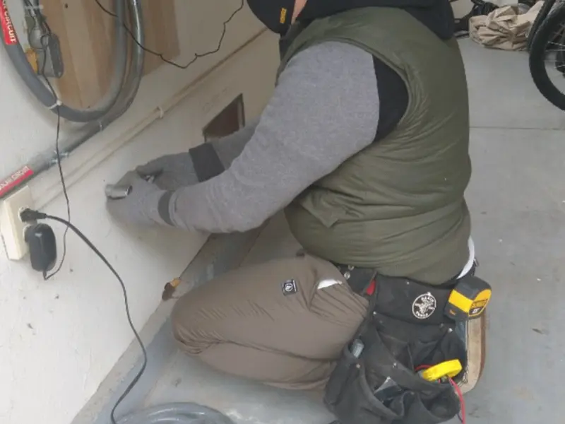Electrician performing outlet wiring in a Summit garage